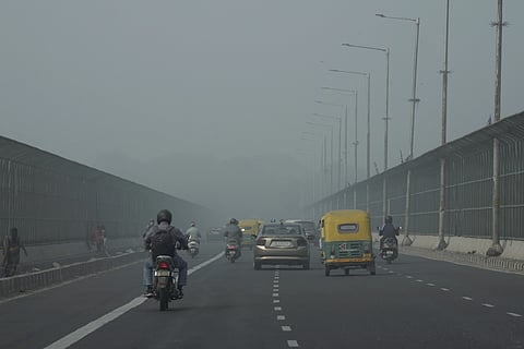 A woman crosses the Kartavya Path amid low visibility due to smog as air quality remains in 'severe' category, in New Delhi, Monday, Nov. 18, 2024. 