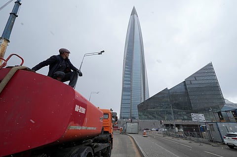 A worker sits on his water tank truck next to the business tower Lakhta Centre, the headquarters of Russian gas monopoly Gazprom in St. Petersburg, Russia, April 27, 2022