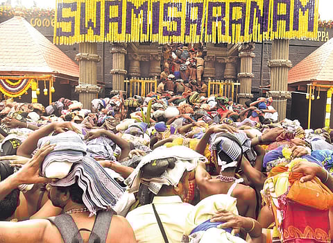Amid the jam-packed queue, devotees walk towards the holy steps to get a glimpse of Lord Ayyappa at Sannidhanam on Saturday.