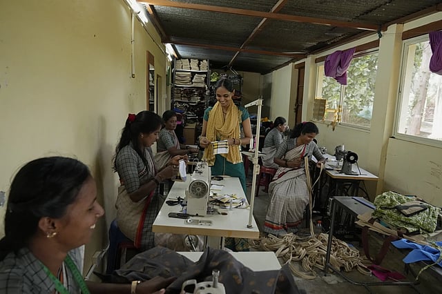 A group of tailors work in a small garage using electric sewing machines to stitch office uniforms and bags at the campus of the Swami Vivekananda Youth Movement, a nongovernmental organization that works to help poor and Indigenous communities, in Kenchanahalli, India, Monday, Sept. 23, 2024.