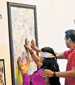 A visitor is guided through the multi-sensory art exhibit 