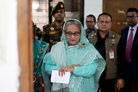 Bangladesh Prime Minister Sheikh Hasina checks her watch as she waits for the official opening time to cast her vote in Dhaka, Bangladesh