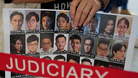 A supporter holds a placard with the photos of some of the 47 pro-democracy defendants outside a court in Hong Kong, on July 8, 2021.