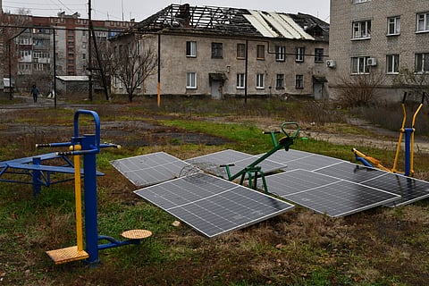 Solar panels sit in the yard of an apartment building in Lyman, Donetsk region, Ukraine, Nov. 20, 2022. 