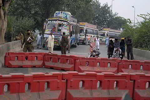 Police officers stand guard on an entry point to motorway leading to Islamabad, which has been closed by authorities due to a planned rally by supporters of imprisoned former Prime Minister Imran Khan's Pakistan Tehreek-e-Insaf party.