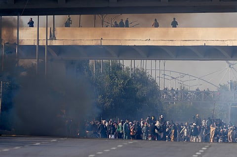 Supporters of imprisoned former Premier Imran Khan's Pakistan Tehreek-e-Insaf party move forwards following police fire tear gas shells to disperse them during clashes in Islamabad, Pakistan, Tuesday, Nov. 26, 2024. 