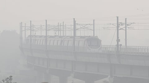 A metro train passes through Mayur Vihar amid the thick layers of smog amid worsening air quality in New Delhi.