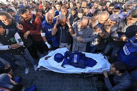 Colleagues and family members pray at the funeral of Al Jazeera cameraman Samer Abudaqa in Khan Younis, Gaza.