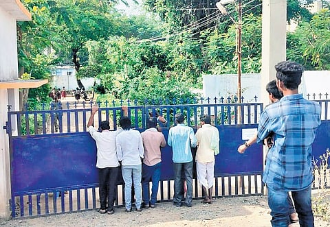 Anxious parents wait outside the school to meet their children after the food poisoning incident; 