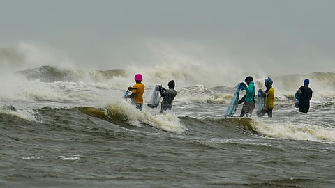 Fishermen move a boat away from the sea amidst an advisory issued by the India Meteorological Department (IMD) not to venture into the sea as a Cyclone Fengal approches. 