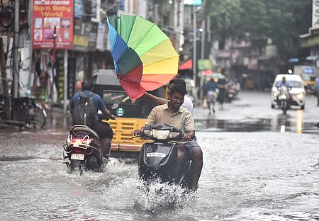 Youngsters struggling with umbrella during the Cyclone Fengal landfall process.