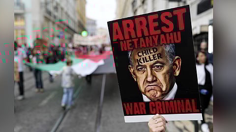 A person holds a poster with a pictures of Israel's Prime Minister Benjamin Netanyahu during a demonstration in support of the Palestinian people in Lisbon, Saturday, Nov. 30, 2024.