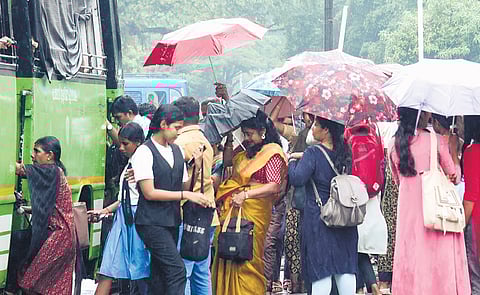 People wait to board a bus in Kochi amid heavy rain on Monday | A Sanesh