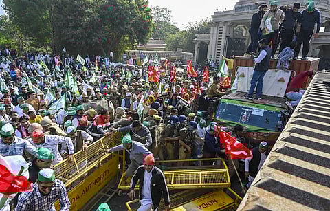 Farmers and Kisan Ekta Sangh members break police barricades during their protest march demanding for the expansion of minimum support prices (MSP) and other benefits, in Noida, Monday, Dec. 2, 2024.