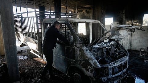 Mohammed Hanani looks at his burnt car following a settler attack that damaged vehicles and houses in the village of Beit Furik, in the occupied West Bank city of Nablus, Wednesday, Dec. 4, 2024