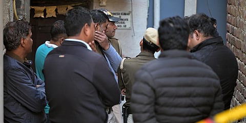 Police officials investigate a triple murder at the Neb Sarai area in New Delhi on Wednesday.