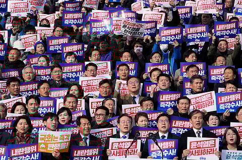 South Korea's main opposition Democratic Party leader Lee Jae-myung, bottom center, shout slogans during a rally against President Yoon Suk Yeol at the National Assembly in Seoul, South Korea, Wednesday, Dec. 4, 2024. The signs read "Yoon Suk Yeol should resign."
