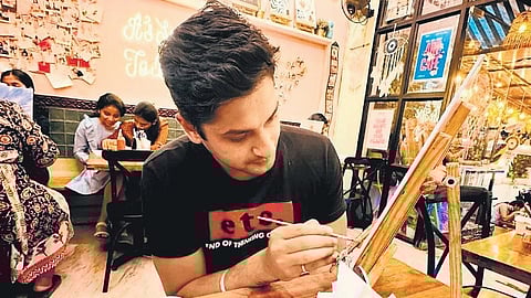 A customer paints at the Artizen Cafe in Pune