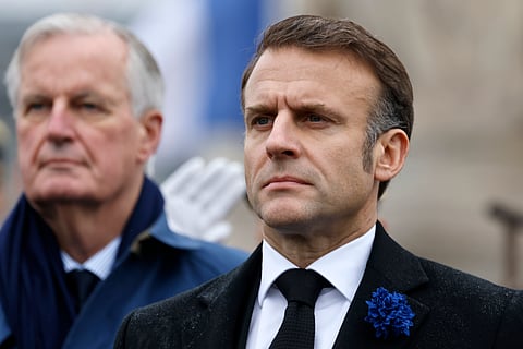 French President Emmanuel Macron, right, and Prime Minister Michel Barnier stand at attention during commemorations marking the 106th anniversary of the November 11, 1918, Armistice, ending World War I, at the Arc de Triomphe in Paris, Monday, Nov. 11, 2024.