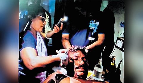 The Manamadurai GH staff treating the patient under a flashlight