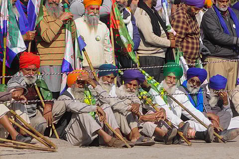 Farmers run for cover after police used teargas to disperse them during their protest at the Shambhu border, in Patiala district, Sunday, Dec. 8, 2024.