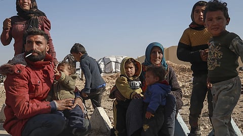 Internally displaced people sit in a camp in Tabqa city, Raqqa governorate, northern Syria on Wednesday, Dec 4, 2024.