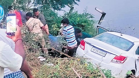 Officials and locals retrieve bodies of the deceased from the car that fell into a pond on Saturday.