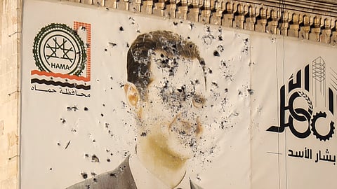 An image of Syrian President Bashar Assad, riddled with bullets, is seen on the facade of the provincial government office in Hama, Syria, Friday, Dec. 6, 2024.