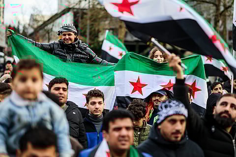 Syrians wave Syrian opposition flags at a rally in Wuppertal, Germany, Sunday, Dec. 8, 2024, following the fall of Syrian president Bashar Assad’s government. 