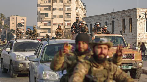 Syrian opposition fighters ride along the streets in the aftermath of the opposition's takeover of Hama, Syria, Friday, Dec. 6, 2024.