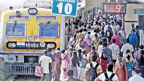 Passengers wait to board a train at Egmore railway station on Sunday