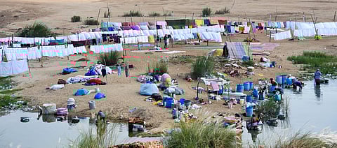 Laundry workers  washing clothes and drying them on the banks of Kollidam river in Srirangam.