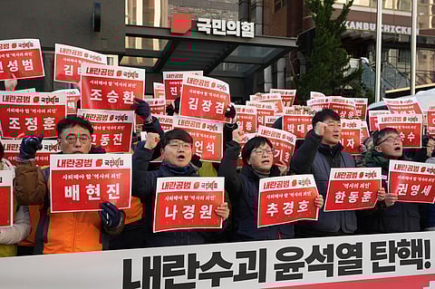 Members of the Korean Confederation of Trade Unions shout slogans as they hold signs carrying the names of the ruling party's lawmakers who didn't vote at the impeachment motion last week, during a rally in front of the ruling People Power Party's head office in Seoul, South Korea, Monday, Dec. 9, 2024. 