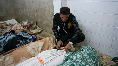 A Palestinian man mourns over the body of a victim following an Israeli bombardment, at the morgue of Al-Aqsa Martyrs hospital in Deir al-Balah, Gaza Strip, Sunday, Dec. 8, 2024