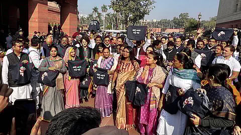 Opposition MPs protest outside the gates carrying black 'jholas' (bags) with caricatures of Prime Minister Narendra Modi and billionaire Gautam Adani printed on it.