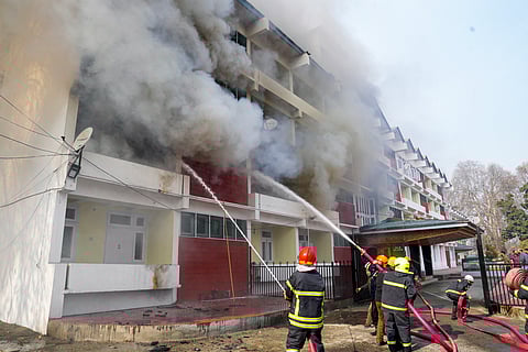 Firefighters douse a fire which broke out at the MLA Hostel, in Srinagar