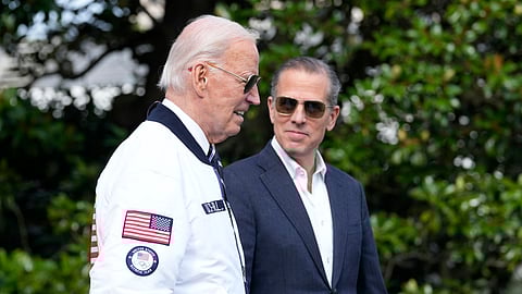 US President Joe Biden, wearing a Team USA jacket and walking with his son Hunter Biden, heads toward Marine One on the South Lawn of the White House in Washington, July 26, 2024. 