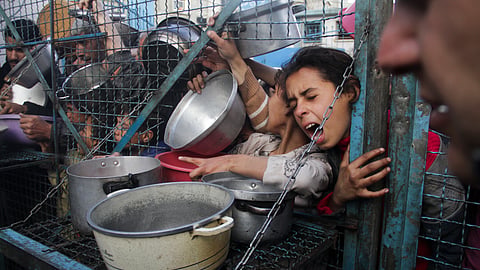FILE - Palestinians line up to receive free meals at Jabaliya refugee camp in the Gaza Strip on March 18, 2024.