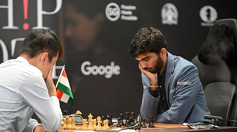 China's chess grandmaster Ding Liren (L) and India's grandmaster Gukesh Dommaraju (R) compete in game 14 of the 2024 FIDE World Championship in Singapore on December 12, 2024.
