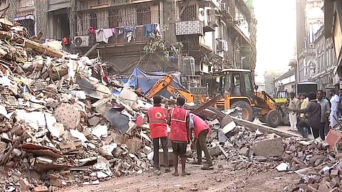 A bulldozer being used to clear the debris after a vacant building partially collapsed, at the Bhendi Bazar area of south Mumbai.