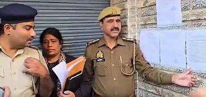The Bengaluru police team pasting notice on house of the Singhania family. 