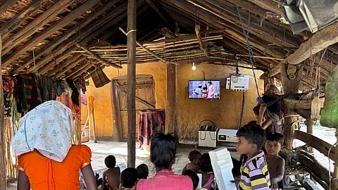 Children watching educator programmes and cartoons on solar television. 