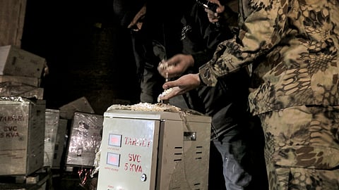 A Syrian rebel fighter inspects pills of Captagon, a brand name of the psychostimulant drug Fenethylline, discovered at a drug manufacturing facility in the city of Douma.
