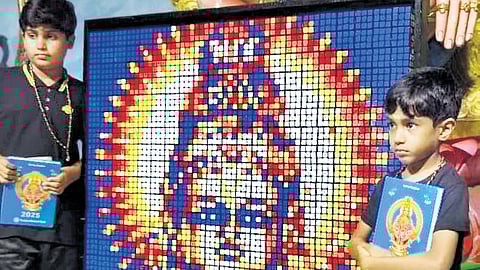 Abhinav Krishnan, 10, and Advaith Krishnan, 6, stand beside their portrait of Lord Ayyappa made using Rubik’s Cube, at Sree Dharma Sastha auditorium  in Sabarimala 