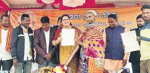 Deputy CM Pravati Parida handing over a land patta to a Bonda woman. 