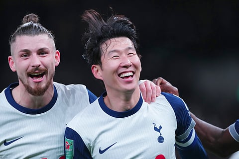 Tottenham's Son Heung-min, right, celebrates after scoring his side's fourth goal during the English League Cup quarter-final soccer match between Tottenham and Manchester United, at the Tottenham Hotspur Stadium in London, Thursday, Dec. 19, 2024. 