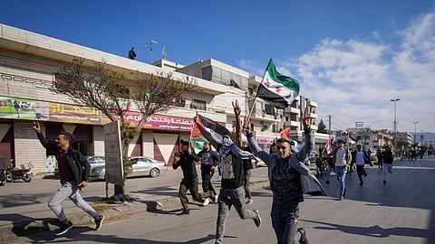 Syrians celebrate the fall of Bashar Assad's government in the town of Bar Elias, Lebanon, near the border with Syria, Sunday, Dec. 8, 2024.