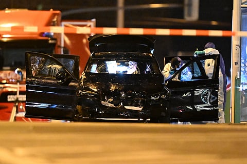 Forensics work on a damaged car sitting with its doors open after a driver plowed into a busy Christmas market in Magdeburg, Germany, early Saturday, Dec. 21, 2024.