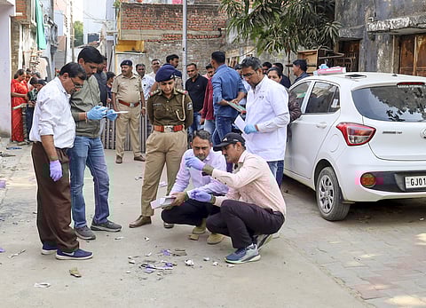 Forensic team examines the spot after a parcel containing an electronic circuit and batteries delivered to a house exploded, in Ahmedabad.