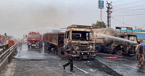 Firefighters extinguish the fire at the site of the accident after a truck loaded with a chemical collided with some other vehicles and caught fire on the Jaipur-Ajmer Highway, in Jaipur.